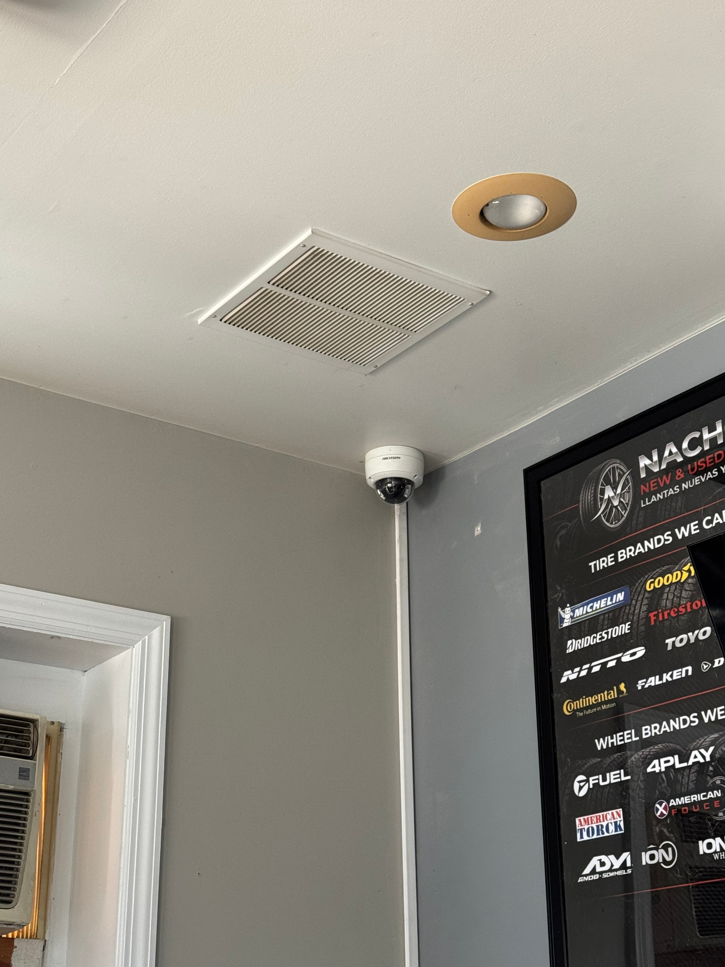 Interior Hikvision dome security camera mounted in business lobby ceiling corner