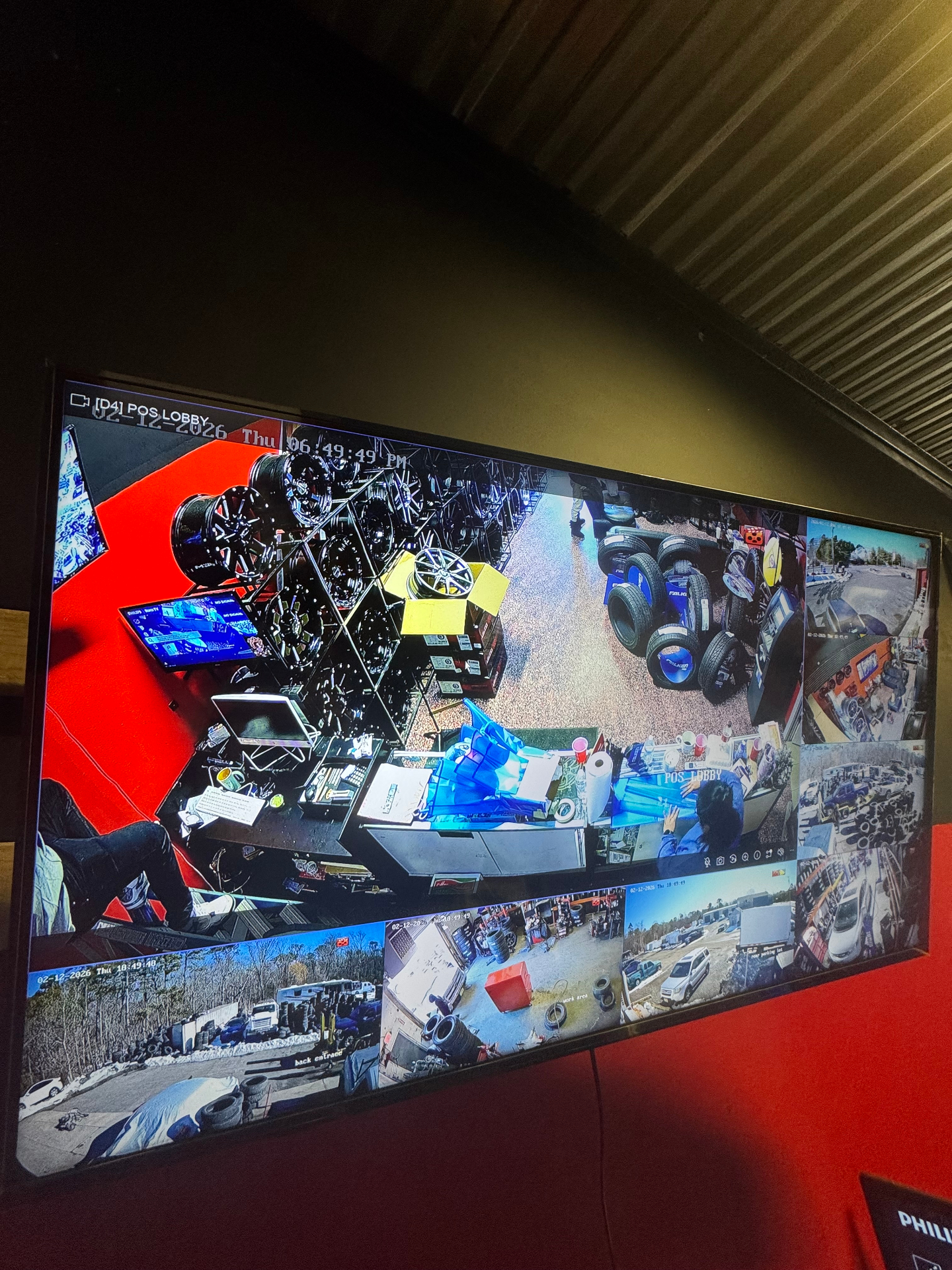 Wall-mounted multi-channel security camera monitoring station displaying live business surveillance feeds